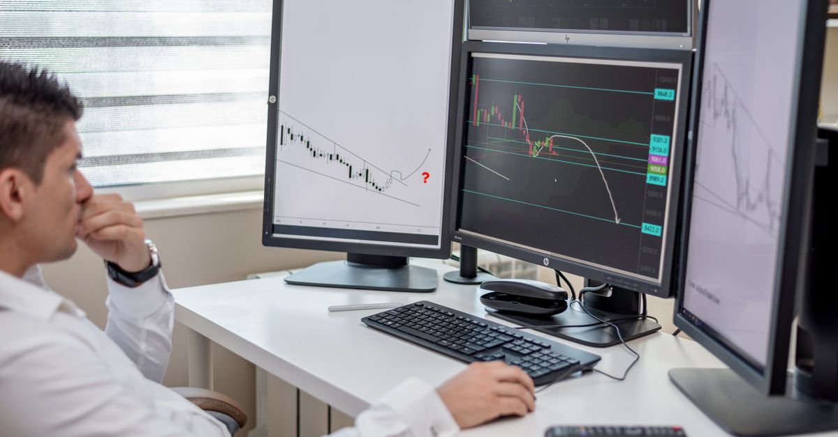 Financieel analist bestudeert Bitcoin en cryptokoersen op meerdere schermen